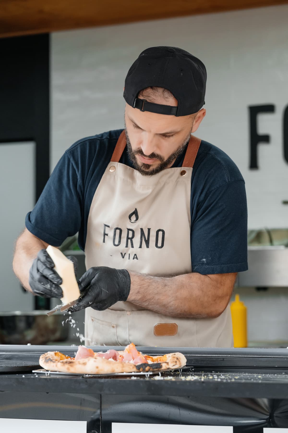 Guests gathered around the serving table at a corporate event catered by Forno Via